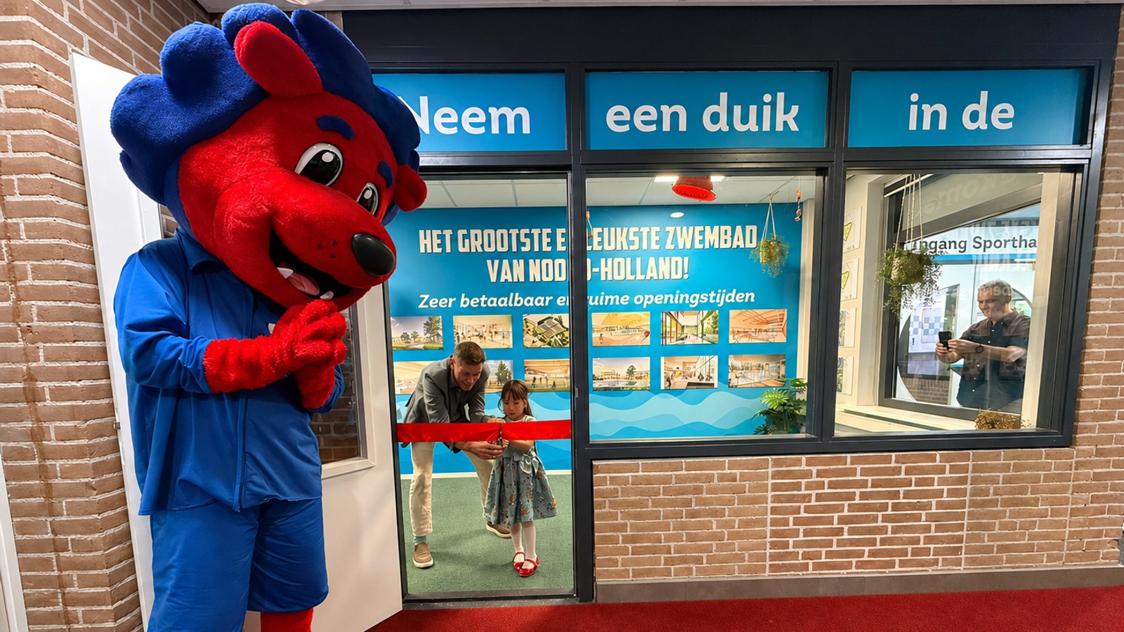 Onder toeziend oog van mascotte Freddy Fit openen Mayla Ruitenberg en Eddy Bakker samen de expositieruimte van het toekomstige zwem- en sportcomplex Hoornse Vaart 1.jpeg