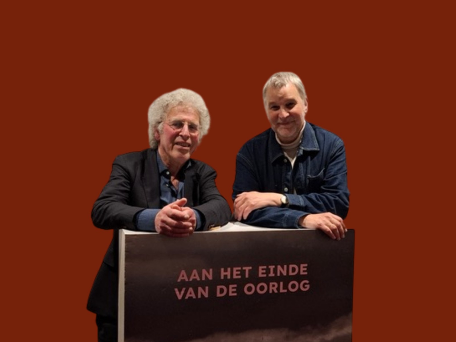 Twee personen achter podium met boektitel, oranje achtergrond